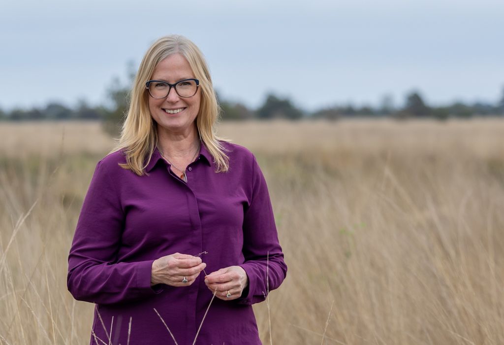 foto van Nanda Niemeijer in goudgeel gras met paarse blouse